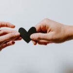 Relationships - two person holding papercut heart