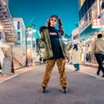 Trends - woman in green jacket stands and pose on street