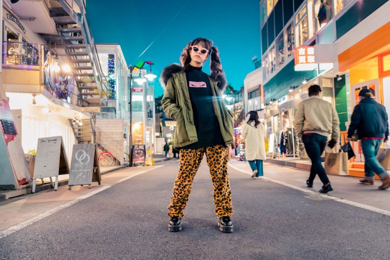 Trends - woman in green jacket stands and pose on street