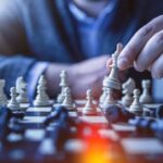 Strategy - depth of field photography of man playing chess