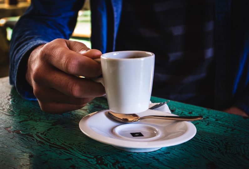 Consistency - person holding white ceramic mug on saucer