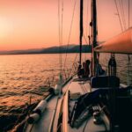 Visuals - white and black sailboat during sunset