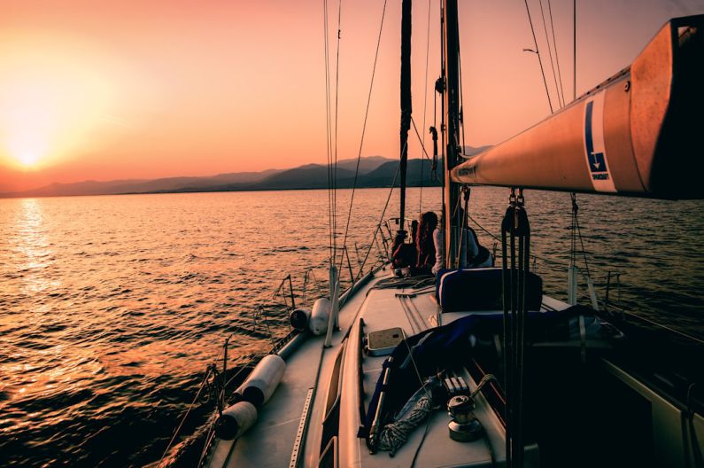 Visuals - white and black sailboat during sunset