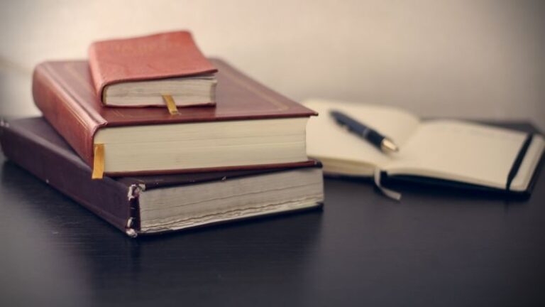 Copywriting - selective focus photography of three books beside opened notebook